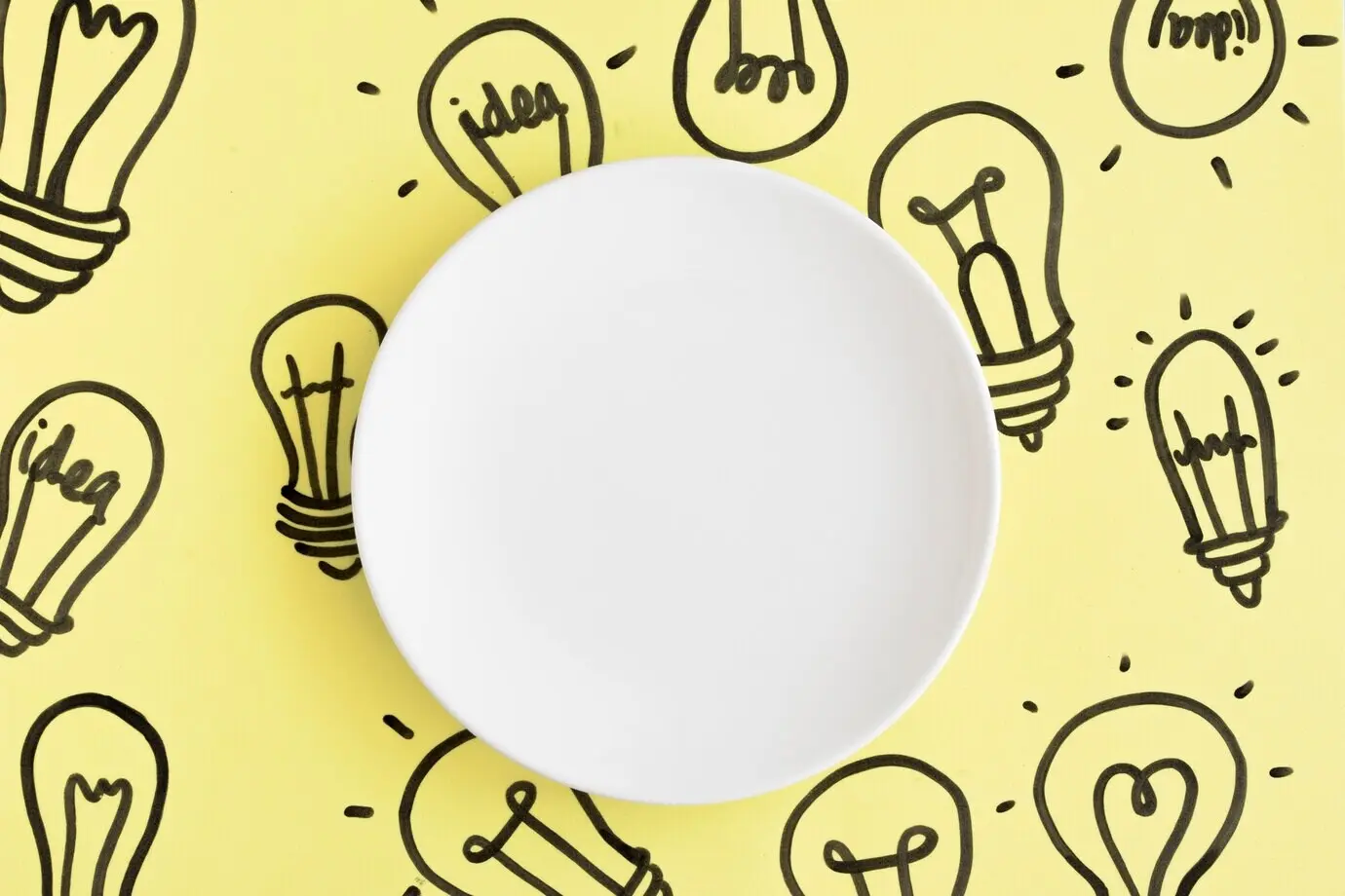Leerer weißer Teller auf handgezeichnetem Glühbirnenhintergrund.