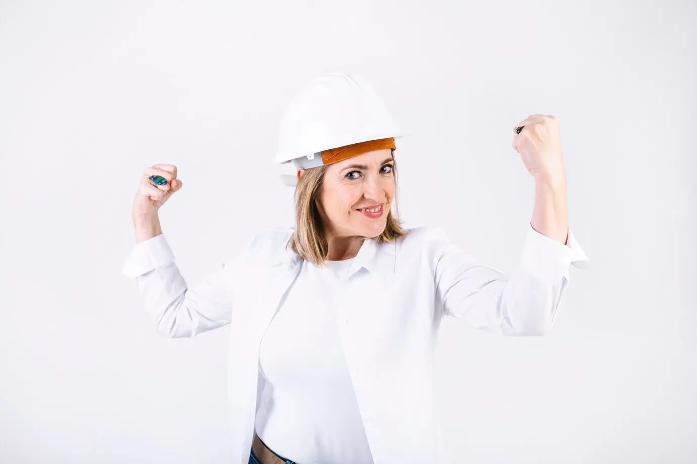 Eine Frau im Helm zeigt ihre Muskeln.